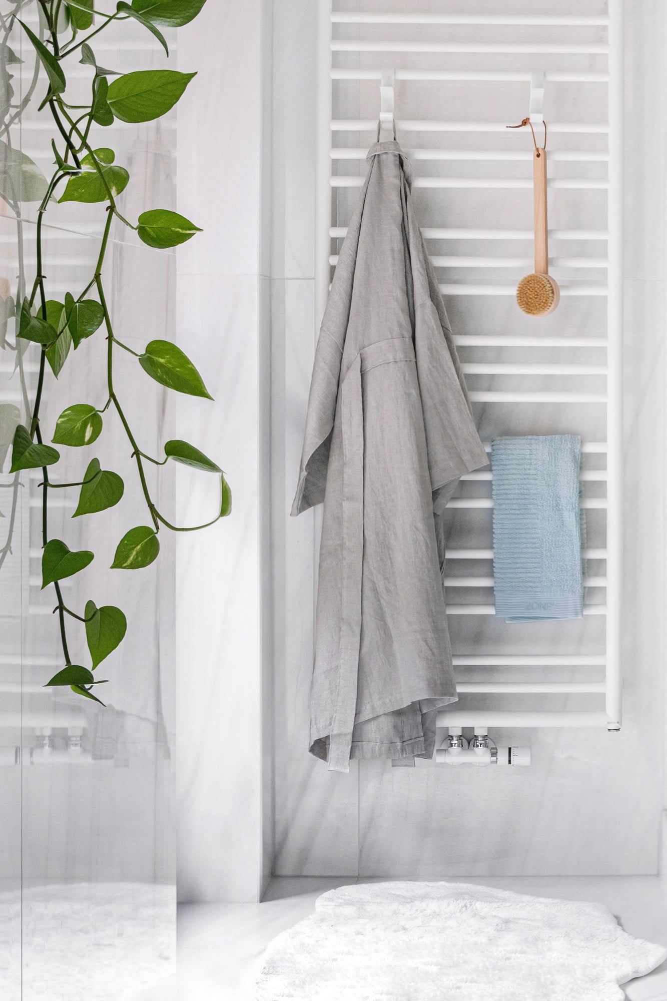Ani v koupelně nechybí přírodní materiály – lněný župan a bambusový kartáč. 