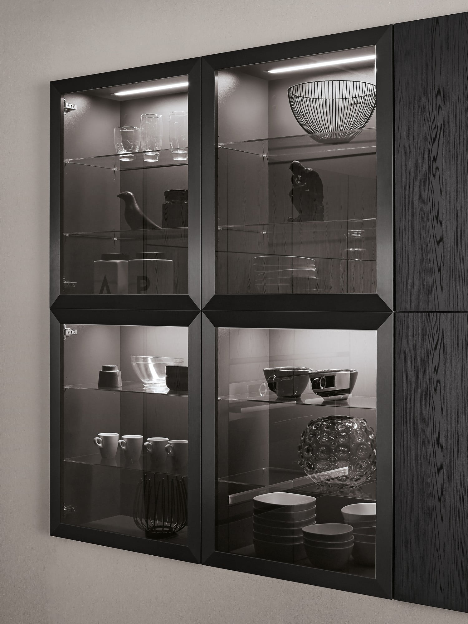Vzdušnosti a prostoru v černé kuchyni docílíte prosklenými skříňkami nebo otevřenými policemi.